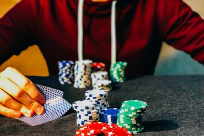 person sitting near poker chips